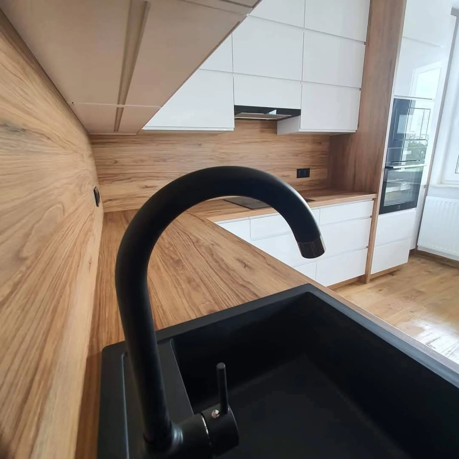 Cocina blanca y madera con grifo negro
